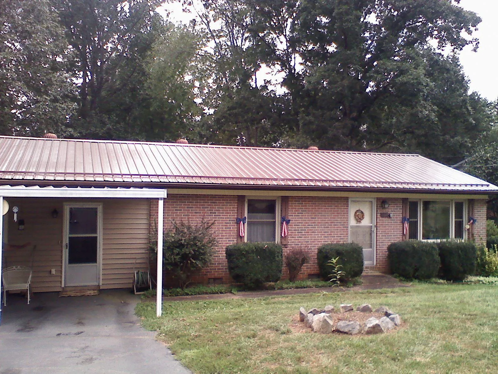 Bronze metal roof and carport on a brick ranch home — Roof Repair work by our crew in Newport